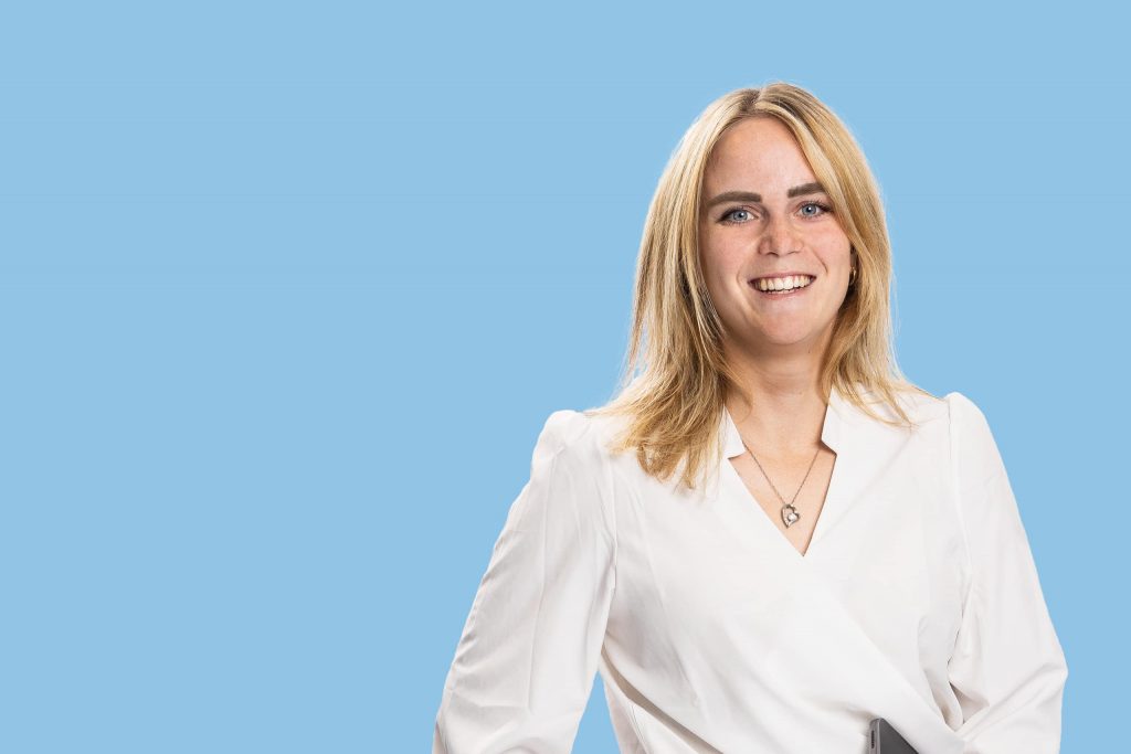 Jurist Esmée, blauwe achtergrond en mens met blond haar en witte blouse aan.