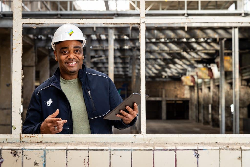 man met tablet in hand bij bedrijf