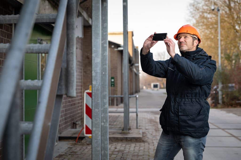 man maakt foto van gebouw
